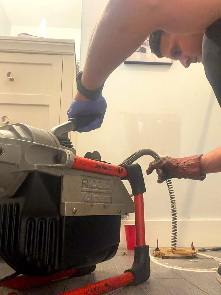 Drain cleaning machine unclogging a sewer line in Miami by 305 Elite Plumbing